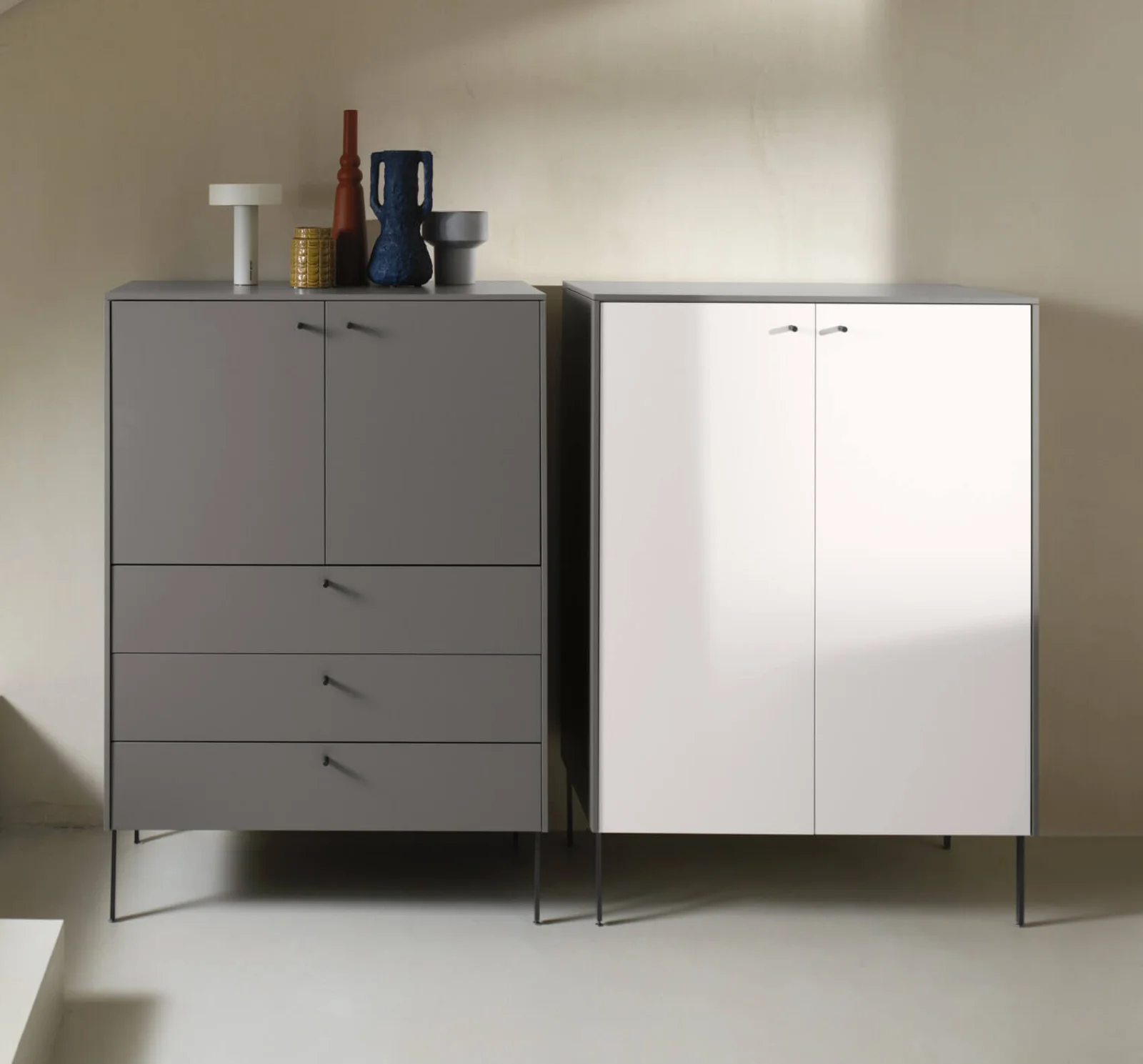 Armoires modernes côte à côte avec façades contrastées, objets décoratifs et design minimaliste