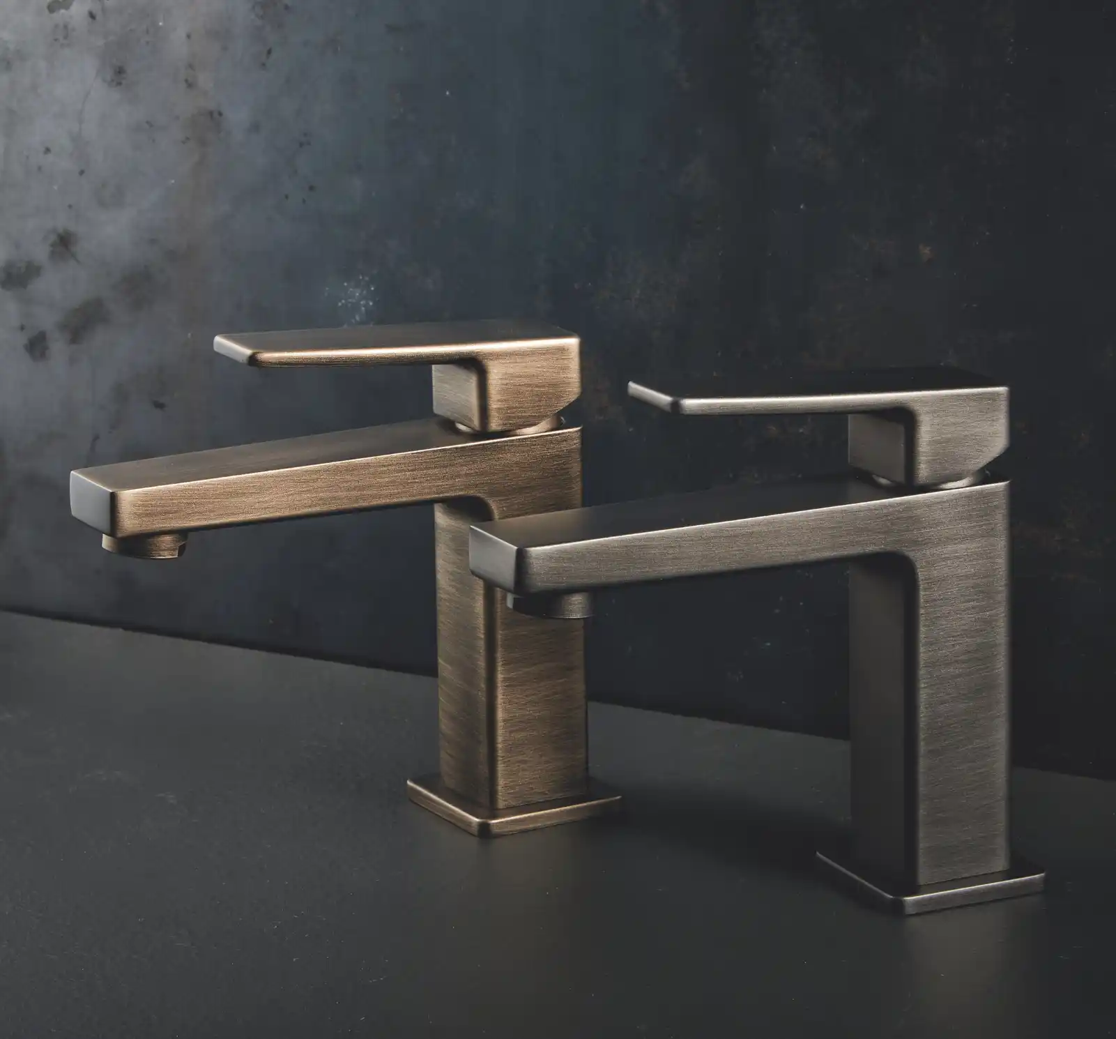 Robinetterie contemporaine avec finitions bronze et inox sur plan sombre, ambiance élégante et minimaliste